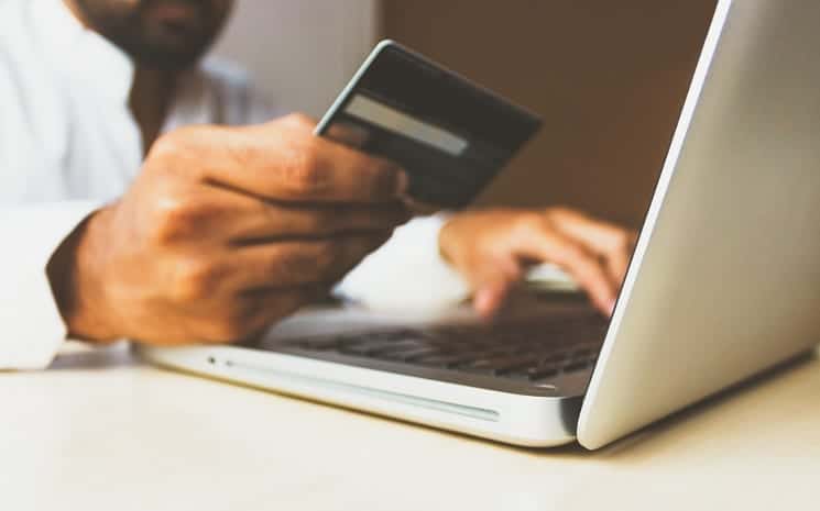 Fintechs de Crédito: pessoa segurando um cartão enquanto faz uma compra online